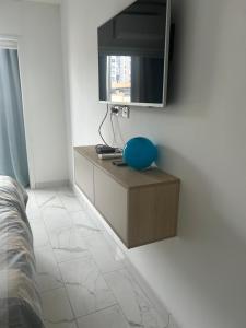 een slaapkamer met een tv aan een witte muur bij Le Grand Bleu in Nice