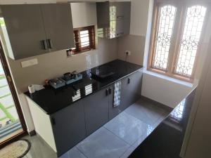 a kitchen with a black counter top and some windows at Sapphire Haven in Varkala
