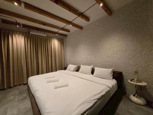 a bedroom with a large bed with white sheets at The Ten Poolvilla Huahin in Hua Hin