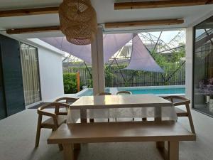 a table and chairs in a room with a pool at The Ten Poolvilla Huahin in Hua Hin +40 photos