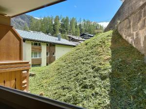 a hill covered in grass next to a building at Studio Gornera - Charming & Cozy in Zermatt