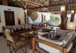a living room with couches and a table at Mvuvi Fishing Lodge in Watamu