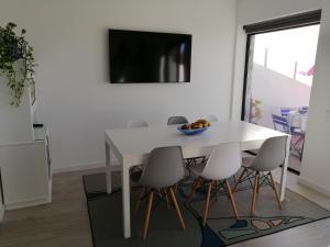 a white dining room table with chairs and a bowl of fruit on it at Ferreirinhas - Beach House in Vila do Conde