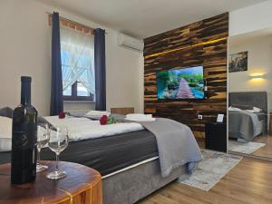 a bedroom with a bed and a wine bottle on a table at Plitvice Streaming in Prijeboj