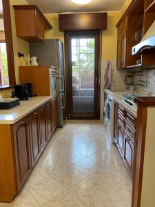 a kitchen with wooden cabinets and a stainless steel refrigerator at Domus Ciampino 4 bedrooms apartment in Ciampino +35 photos