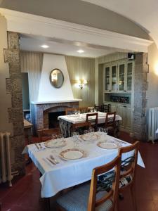 Un comedor con mesa y sillas y chimenea. en Hotel restaurant Xalet la Coromina, en Viladrau