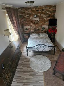 比尔扎伊Pas Ligita的一间带床和砖墙的卧室
