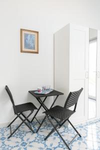 una mesa negra y 2 sillas en una habitación en Villa Alba - Smeraldo, en Amalfi 6 fotos más