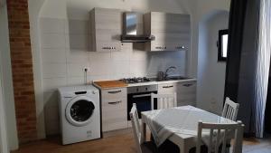 a kitchen with a washing machine and a table with a tableablish at La Casa di MaGioLò in Serracapriola