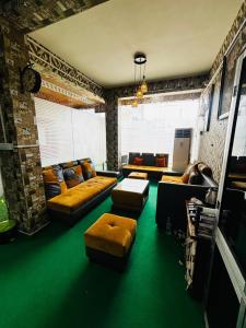 a living room with couches and a green floor at Panama & Panama Hotel and Restaurant in New Town