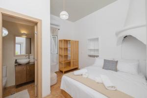 罗德镇Cleopatra's Backyard的白色的卧室设有一张大床和一间浴室。