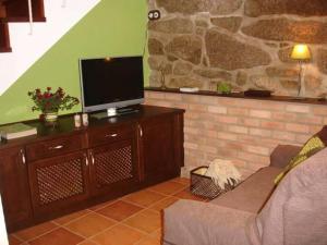 a living room with a couch and a flat screen tv at Casita curbeiros in O Grove