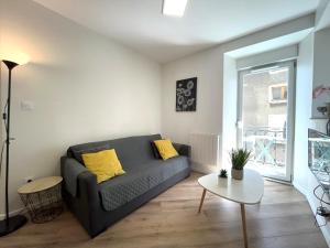 una sala de estar con un sofá y una mesa en Le Jaurès 2 - proche gare, en La Roche-sur-Foron