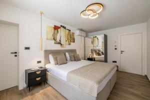 a bedroom with a large bed and a chandelier at Villa Lavea in Trogir