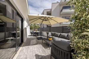 a patio with a couch and an umbrella at Villa Lavea in Trogir