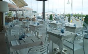 a group of tables and chairs with glasses on them at Hotel Roca Plana in L'Ampolla