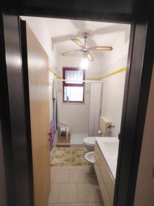 a bathroom with a toilet and a ceiling fan at Dimora Violette in Torre Pali 
