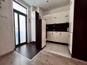 une cuisine avec des placards blancs et une grande fenêtre dans l'établissement 120 m2 apartment in the centre of the old town, à Bratislava