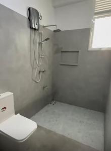 a white bathroom with a toilet and a shower at Casa Lashmika in Hikkaduwa +7 photos
