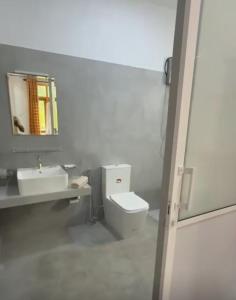 a bathroom with a toilet and a sink and a mirror at Casa Lashmika in Hikkaduwa