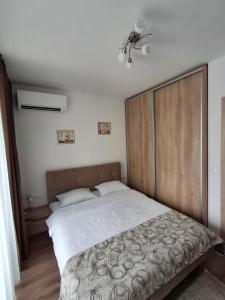 Un dormitorio con una cama grande con cabecero de madera. en Azur Oasis, en Varna