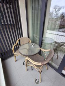 Una mesa de cristal y dos sillas en un balcón. en Azur Oasis, en Varna 3 fotos más