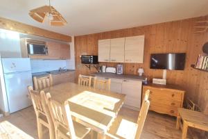Il comprend une cuisine avec une table en bois et un réfrigérateur. dans l'établissement Votre Havre de Paix en Montagne - chalet 6 personnes avec piscine et sauna, à La Féclaz 16 autres photos