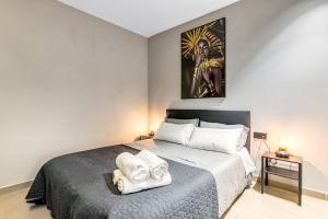 a bedroom with a large bed with towels on it at City Suites in Valencia