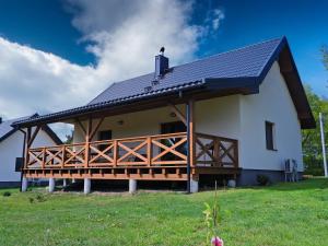 a large white house with a black roof at Ostoja nad Gilem in Ostrów Wielki