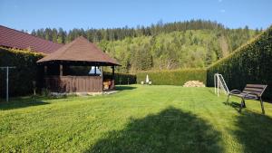 ein Pavillon mit einer Bank im Garten in der Unterkunft Forest View Cottage in Voroneţ