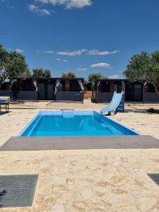 a pool with a slide and a playground at Vi&No Mobile Home - Camping Pirovac in Pirovac