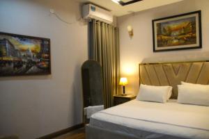 une chambre avec un lit et un tableau au mur dans l'établissement Luxury 2-BHK Apartment, à Islamabad