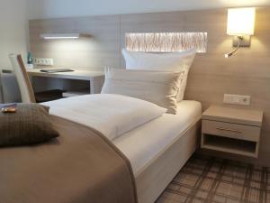 niewielka sypialnia z łóżkiem i biurkiem w obiekcie Hotel-Restaurant Goldenstedt w mieście Delmenhorst
