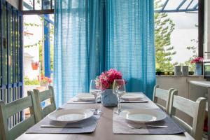 a table with plates and glasses and flowers on it at Blue Cactus village center in Agia Pelagia