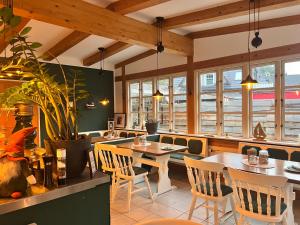 a restaurant with tables and chairs and windows at Villa Wiesenau by Restaurant WIESENAU in Prerow