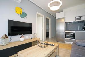 a living room with a large flat screen tv at Kelyfos Sunset luxury apartment in Neos Marmaras