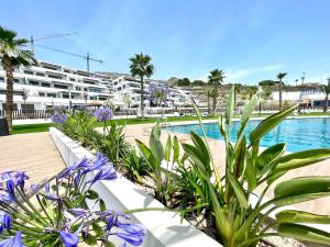 a swimming pool with plants in front of a building at Seascape Luxury Finestrat in Finestrat