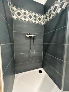 a bathroom with a shower with black and white tiles at Studio cosy in Frontignan