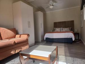 a living room with a bed and a couch at Wild Mountain Cottages in George