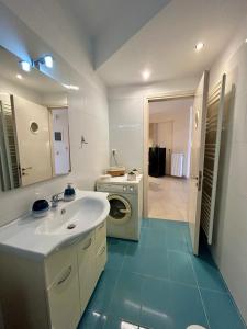 Un baño con lavabo y lavadora. en Feel at home - Kalamata - Near the center, en Kalamata