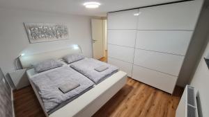 a white bedroom with a bed and white cabinets at Greg's House Apartments in Ljubljana