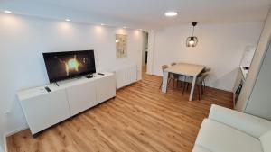 a living room with a flat screen tv and a table at Greg's House Apartments in Ljubljana