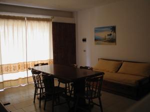 a living room with a table and chairs and a couch at Residence Spiaggia Bianca in Golfo Aranci