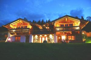 une grande maison en bois avec des lumières de Noël. dans l'établissement Ferienhaus im Almdorf in Flachau, à Flachau
