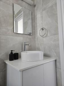 a bathroom with a white sink and a mirror at Sea view Penthouse Universal Residences in Paphos