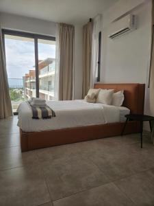 a bedroom with a large bed with a large window at Sea view Penthouse Universal Residences in Paphos