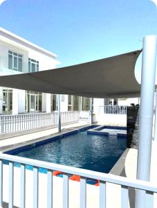 a swimming pool with a shade on a balcony at Al Rajhi House in Al Maşna‘ah