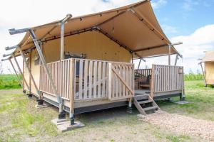 WolphaartsdijkGlamping De Zuidvliet Nr 18的田野上带屋顶的凉亭