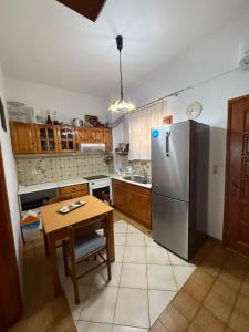 a kitchen with a table and a stainless steel refrigerator at Fiore House in Parga