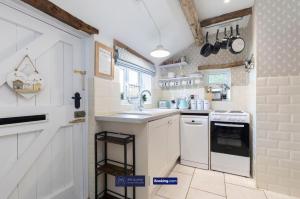 eine kleine Küche mit Spüle und Herd in der Unterkunft Pet Friendly Cottage By KBS Stayhub Short Lets & Serviced Accommodation Stonehouse With Log Fire, Parking in Gloucestershire